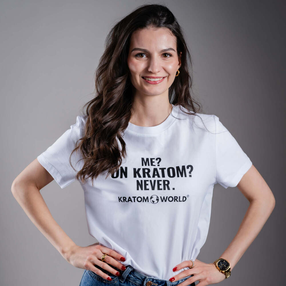 Dámské tričko Kratom World s motivem „Me? On Kratom? Never.“ – originální merch pro milovníky kratomu a fanoušky značky Kratom World, stylový streetwear design s výrazným potiskem, pohodlné tričko pro každodenní nošení, ideální do města, na eventy i jako sběratelský kousek pro komunitu kolem kratomu logo detail